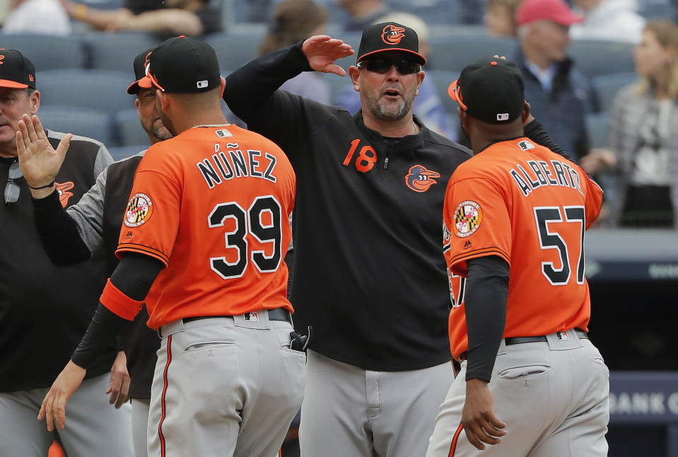 FILE - In this Saturday, March 30, 2019 file photo,Baltimore Orioles manager Brandon Hyde (18) congratulates players after they defeated the New York Yankees in a baseball game in New York. The win was Hyde's first as a major league manager. There might come a time when Brandon Hyde wakes up in the morning, grabs a newspaper and checks out the standings to see where the Baltimore Orioles stand. For now, the rookie manager simply can’t bear to look. The rebuilding Orioles limped into the All-Star break with a major league worst 27-62 record. (AP Photo/Julie Jacobson, File)