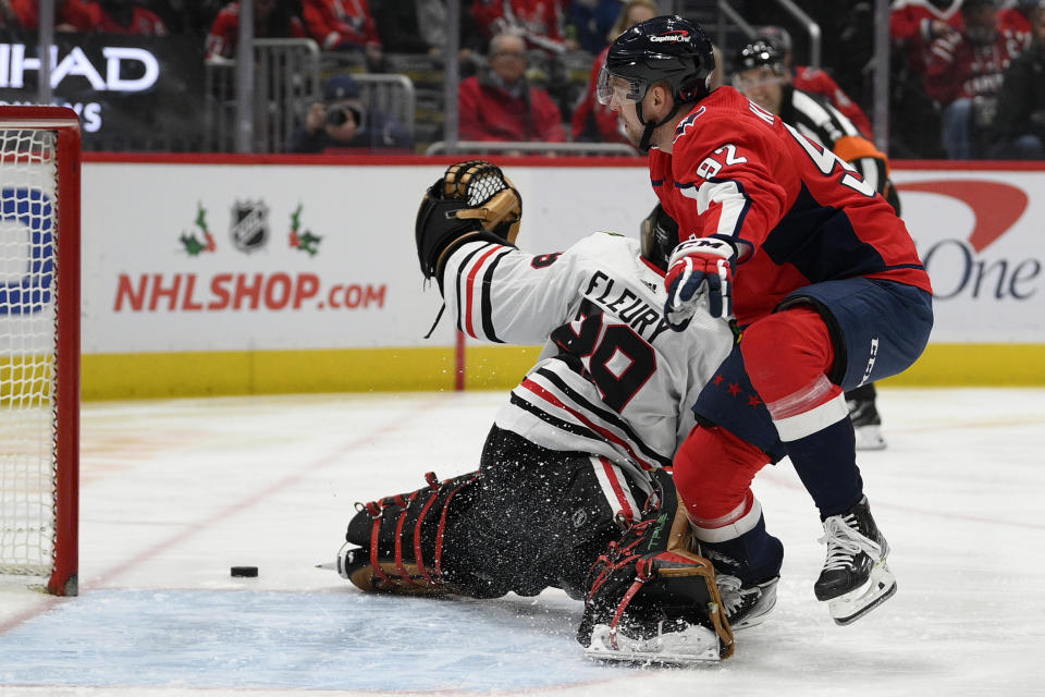 Washington Capitals center Evgeny Kuznetsov (92) collides with Chicago Blackhawks goaltender Marc-Andre Fleury (29) during the first period of an NHL hockey game Thursday, Dec. 2, 2021, in Washington. (AP Photo/Nick Wass)