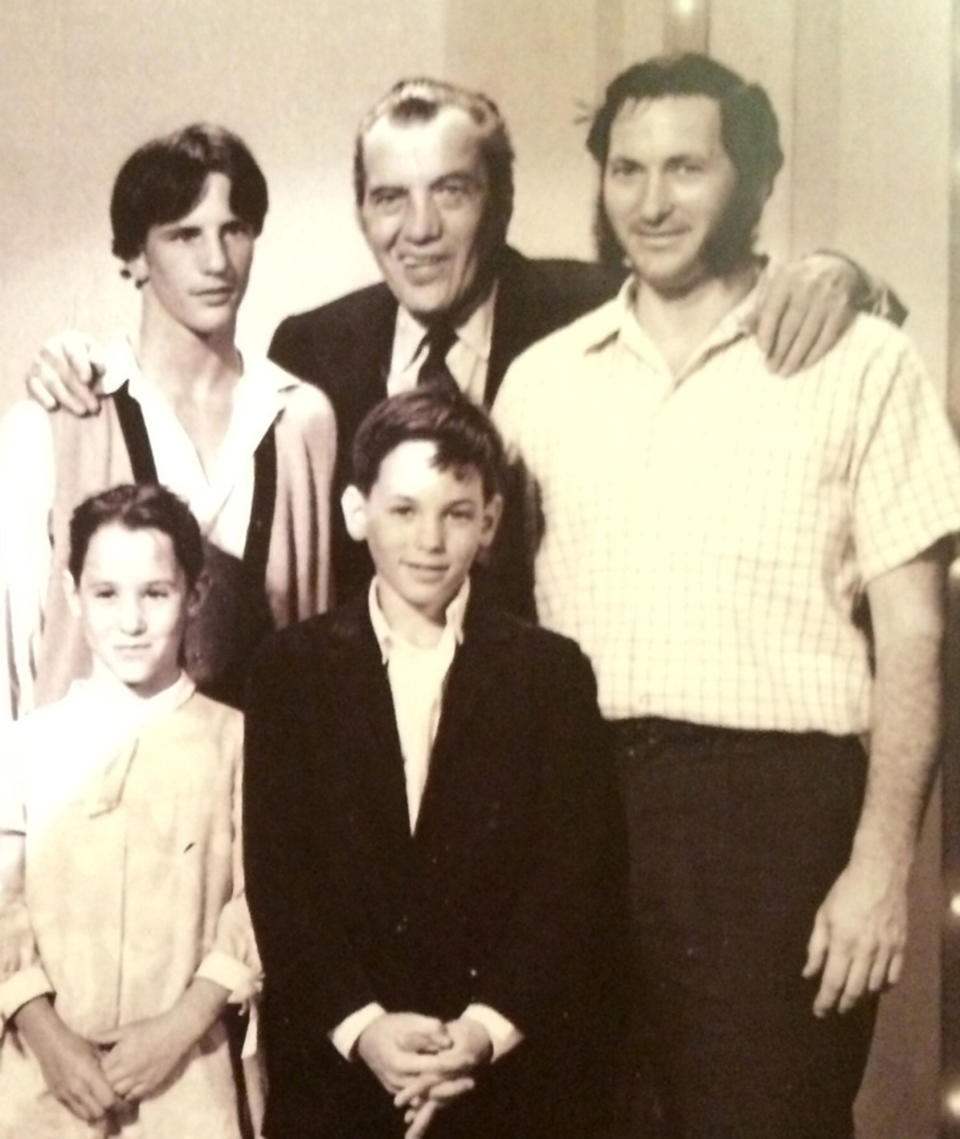 This undated photo provided by Heritage Auctions shows Ed Sullivan, top, center, posing with his arm around Jerry Gort, top right, and members of Gort's family backstage at the New York theater where The Ed Sullivan Show took place. Gort, now 81 and living in California, was a stagehand for the show when the Beatles made their historic television appearance Feb. 9, 1964. Between sets, Gort got all four members of the Beatles to pen their autographs and draw caricatures on a 4-foot-by-2-foot section of a backdrop wall. Now that artifact, believed to be the largest Beatles autograph, is being sold on April 26, 2014, by Heritage Auctions in New York where it could realize $800,000 to $1 million. (AP Photo/Heritage Auctions)