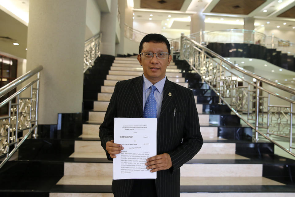 Zamihan Mat Zin’s lawyer Datuk Shaharudin Ali holds a copy of the statement of claims in the lobby of the Kuala Lumpur Court Complex July 17, 2019. — Picture by Yusof Mat Isa