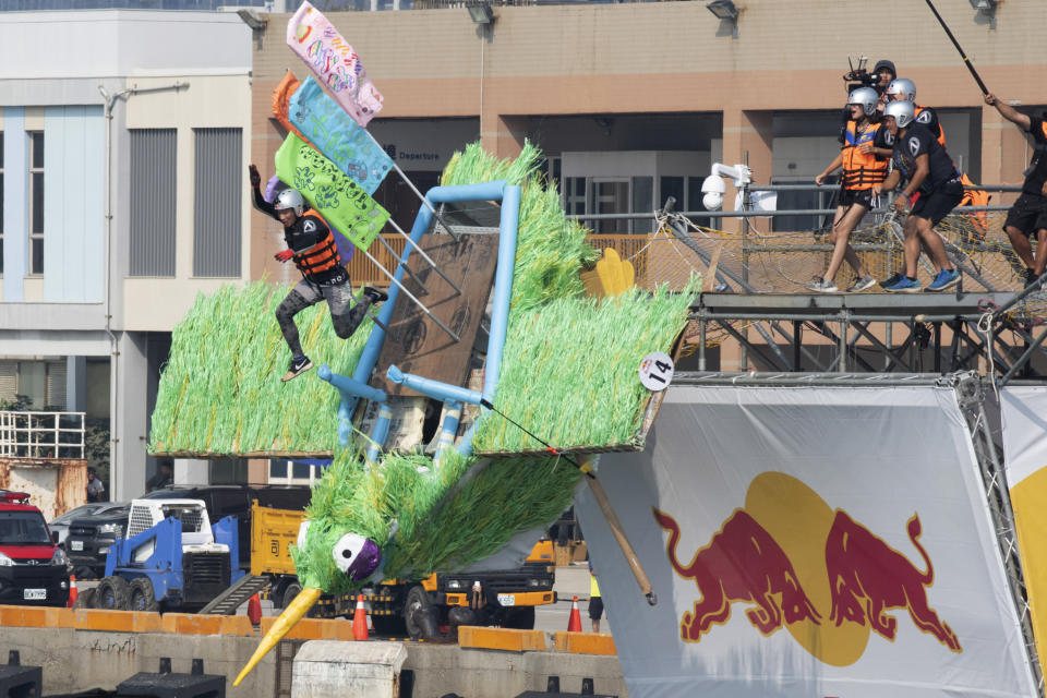 A team member jumps from a platform with a man made flying machine into the harbor in Taichung, a port city in central Taiwan on Sunday, Sept. 18, 2022. Pilots with homemade gliders launched themselves into a harbor from a 20-foot-high ramp to see who could go the farthest before falling into the waters. It was mostly if not all for fun as thousands of spectators laughed and cheered on 45 teams competing in the Red Bull “Flugtag” event held for the first time. (AP Photo/Szuying Lin)