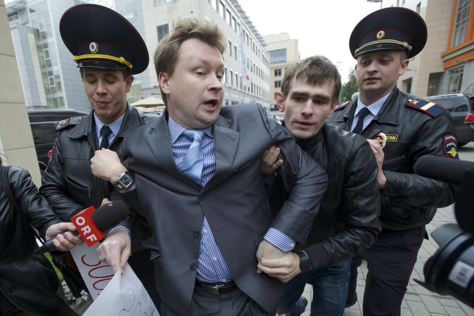 FILE - In this Wednesday, Sept. 25, 2013 file photo, police detain Russia's leading gay rights campaigner Nikolai Alexeyev, center, during a protest outside the Sochi 2014 Winter Olympic Games organizing committee office, in downtown Moscow, Russia. Despite seven months of international protests, Russia's law restricting gay-rights activity remains in place leading up to the winter olympic games. Yet the eclectic campaign has heartened activists in Russia and, without question, caught the attention of its targets - including organizers and sponsors of the Sochi Olympics that open on Feb. 7. (AP Photo/Ivan Sekretarev)