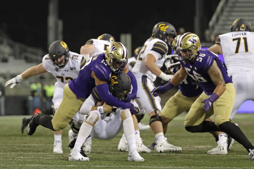 California quarterback Chase Garbers, center, is sacked by Washington linebackers Brandon Wellington, left, and Laiatu Latu (56), during the first half of an NCAA college football game, Saturday, Sept. 7, 2019, in Seattle. (AP Photo/Ted S. Warren)