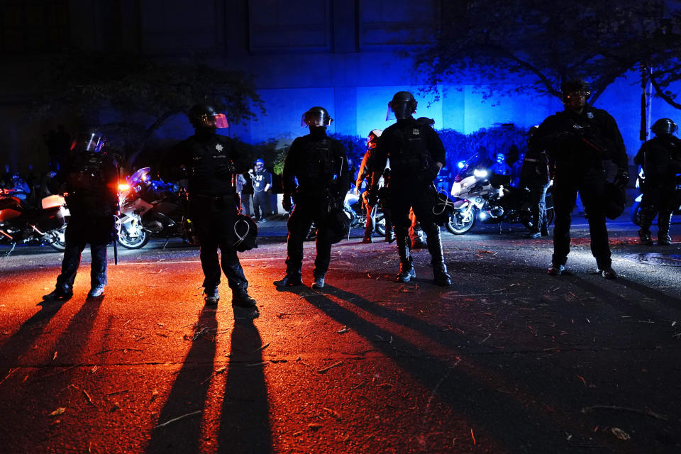 Portland police stand in a street during protests, Saturday, Sept. 26, 2020, in Portland. The protests which began since the police killing of George Floyd in late May often result frequent clashes between protesters and law enforcement. (AP Photo/John Locher)