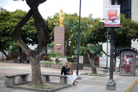 A woman sits next to a banner against the National Constituent Assembly in a street of Caracas, Venezuela, July 24, 2017. The banner reads "No to fraud". REUTERS/Andres Martinez Casares