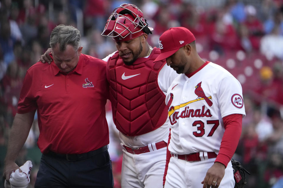 St. Louis Cardinals catcher Willson Contreras, center, leaves a baseball game with the help of trainer Chris Conroy and manager Oliver Marmol (37) after being injured during the eighth inning on opening day against the Toronto Blue Jays Thursday, March 30, 2023, in St. Louis. (AP Photo/Jeff Roberson)