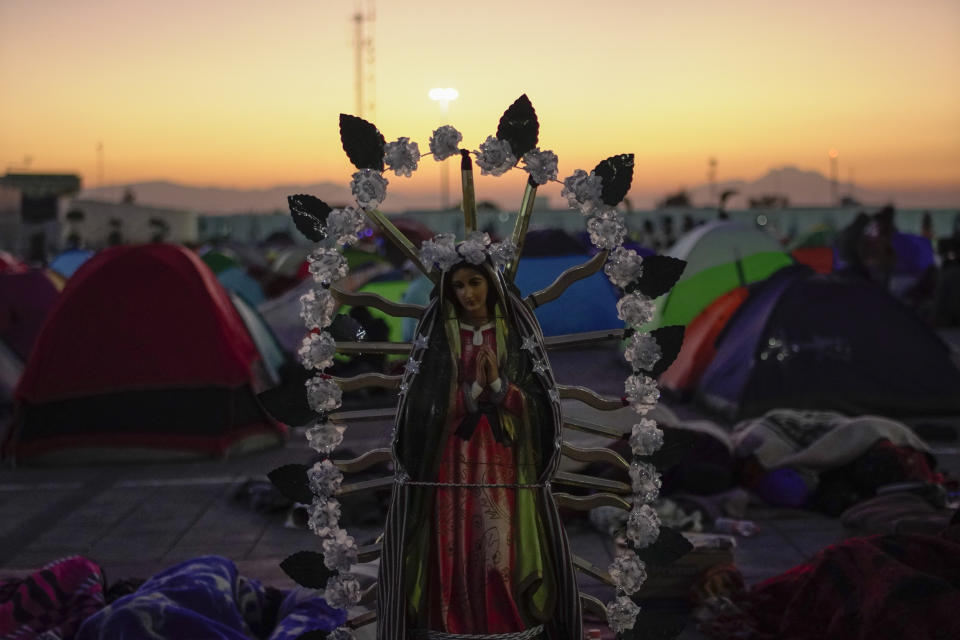 A statue of the Virgin of Guadalupe stands amid pilgrims camping outside the Basilica of Guadalupe in Mexico City, early Monday, Dec. 12, 2022. Devotees of the Virgin of Guadalupe make the pilgrimage for her Dec. 12 feast day, the anniversary of one of several apparitions of the Virgin Mary witnessed by an Indigenous Mexican man named Juan Diego in 1531. (AP Photo/Aurea Del Rosario)