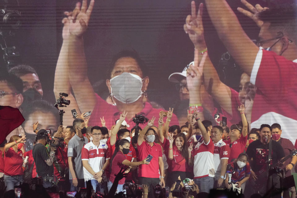 Ferdinand "Bongbong" Marcos Jr. greets the crowd during a campaign rally in Quezon City, Philippines on April 13, 2022. Marcos Jr., son of the late dictator and his running mate Sara, who is the daughter of the outgoing President Rodrigo Duterte, are leading pre-election surveys despite his family's history. (AP Photo/Aaron Favila)