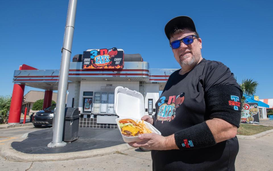Owner Sean DeSmet holds a double cheeseburger and fries order at 3-D Eats’ newest location at the former Checkers Drive-In at the corner of North Pace Boulevard and West Fairfield Drive in Pensacola on Monday, Oct. 9, 2023.