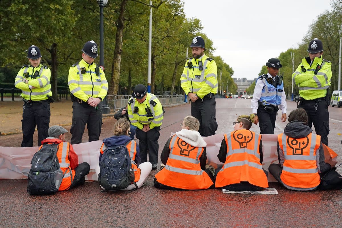 Police speak to campaigners from Just Stop Oil during a protest outside Buckingham Palace (PA)
