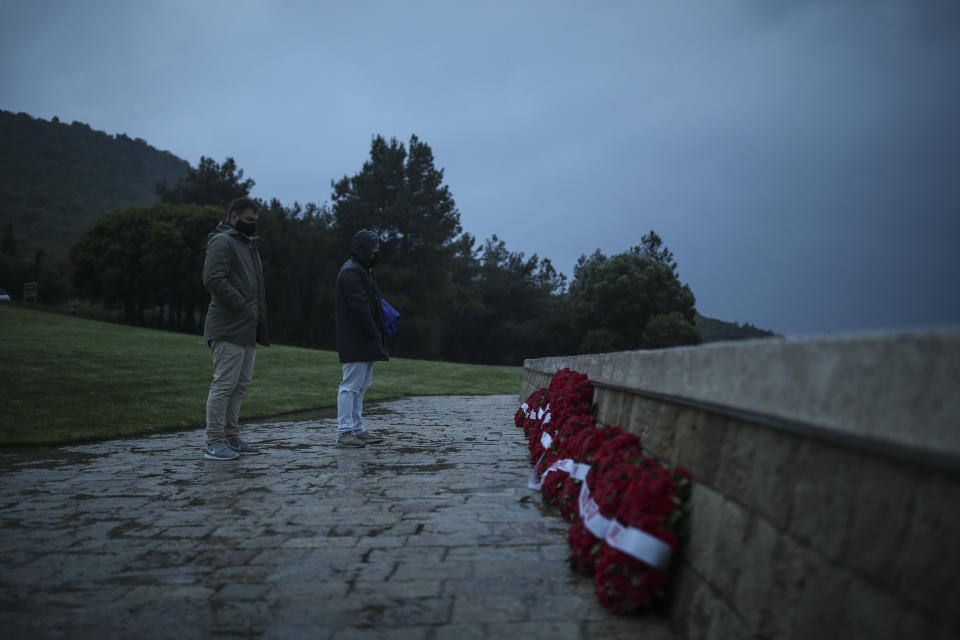 People look at wreaths following the Dawn Service ceremony at the Anzac Cove beach in Gallipoli peninsula, the site of World War I landing of the ANZACs (Australian and New Zealand Army Corps) on April 25, 1915, in Canakkale, Turkey, early Sunday, April 25, 2021. The dawn service ceremony and all other commemorative ceremonies for the 106th anniversary honouring thousands of Australians and New Zealanders who fought in the Gallipoli campaign of World War I on the ill-fated British-led invasion, were small and held without public this year due to the coronavirus pandemic.(AP Photo/Emrah Gurel)
