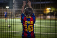 A boy wearing a shirt with the name of Barcelona soccer player Lionel Messi looks at at a soccer match in Banyoles, in Girona province, Spain on Wednesday, Sept. 2, 2020. Lionel Messi's future at Barcelona looked no closer to being resolved after the first meeting between the player's father and club officials on Wednesday ended without an agreement, a person with knowledge of the situation told The Associated Press. (AP Photo/Emilio Morenatti)