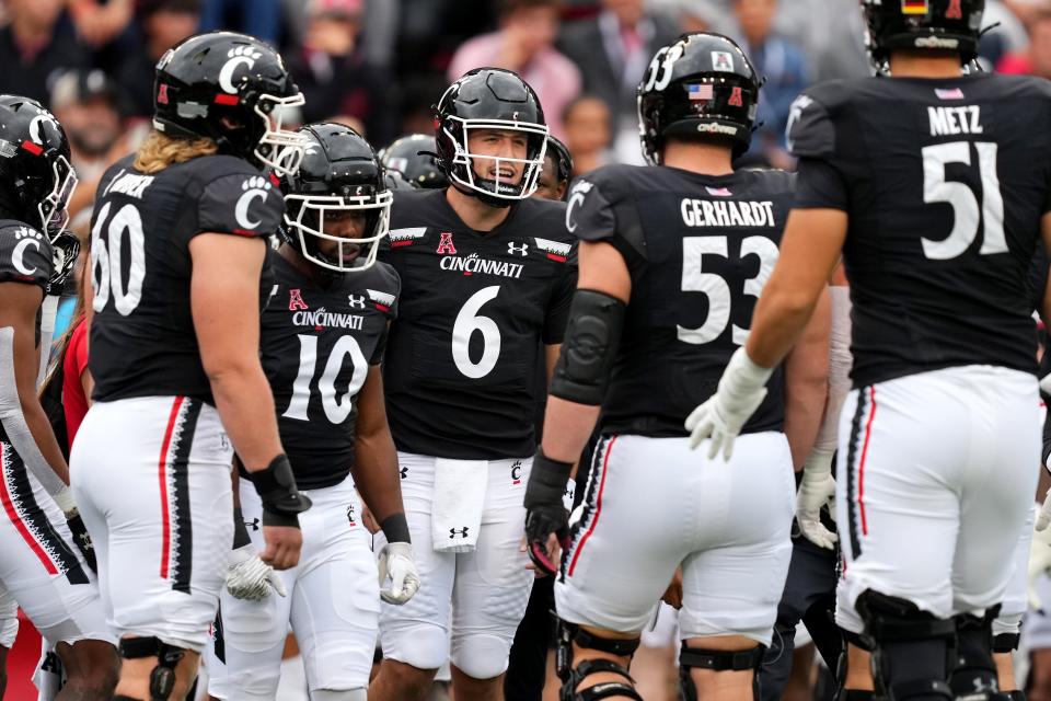 Cincinnati Bearcats quarterback Ben Bryant (6) talks to the offensive unit before the team’s first possession in the first quarter during a college football game against the Navy Midshipmen, Saturday, Nov. 5, 2022, at Nippert Stadium in Cincinnati. 