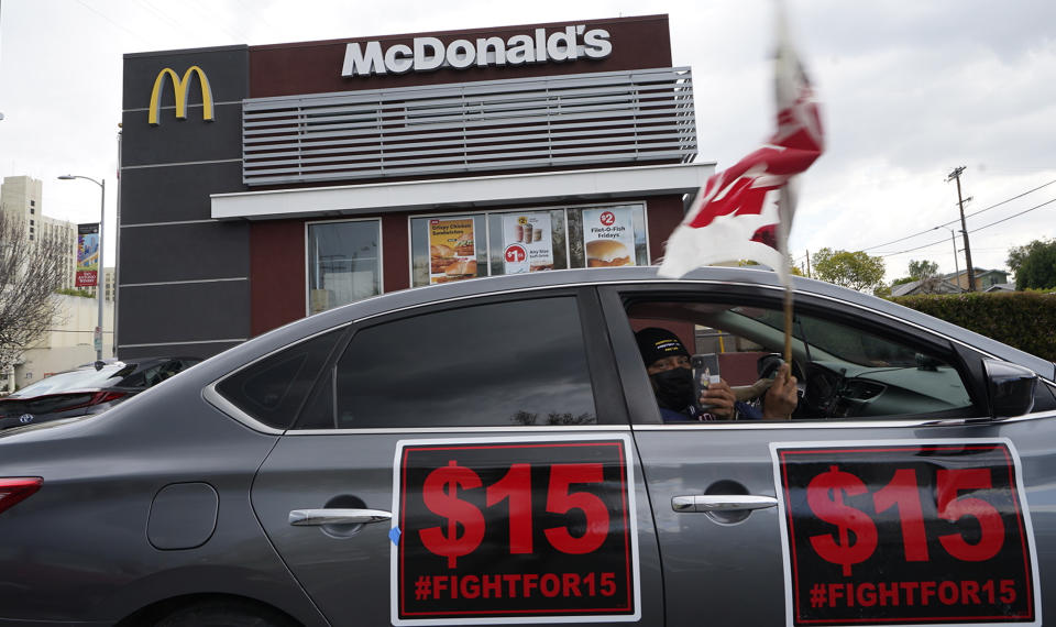 FILE — Fast-food workers drive-through to protest for a $15 dollar hourly minimum wage outside a McDonald's restaurant in East Los Angeles Friday, March 12, 2021. On Monday, Jan. 31, 2022 California lawmakers approved a first-in-the-nation measure by Assemblyman Chris Holden that gives California's more than half-million fast food workers increased power and protections. (AP Photo/Damian Dovarganes, File)