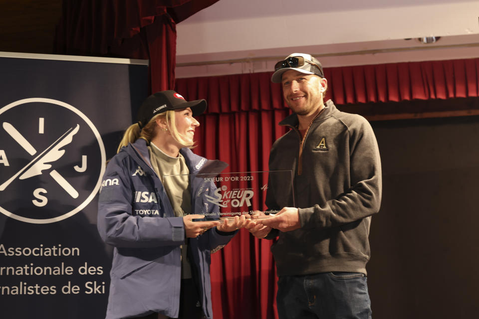 United States' Mikaela Shiffrin, left, receives the "Golden Skier" award from US ski legend Bode Miller, ahead of the alpine ski season's opening races, in Soelden, Austria, Friday, Oct. 27, 2023. (AP Photo/Alessandro Trovati)