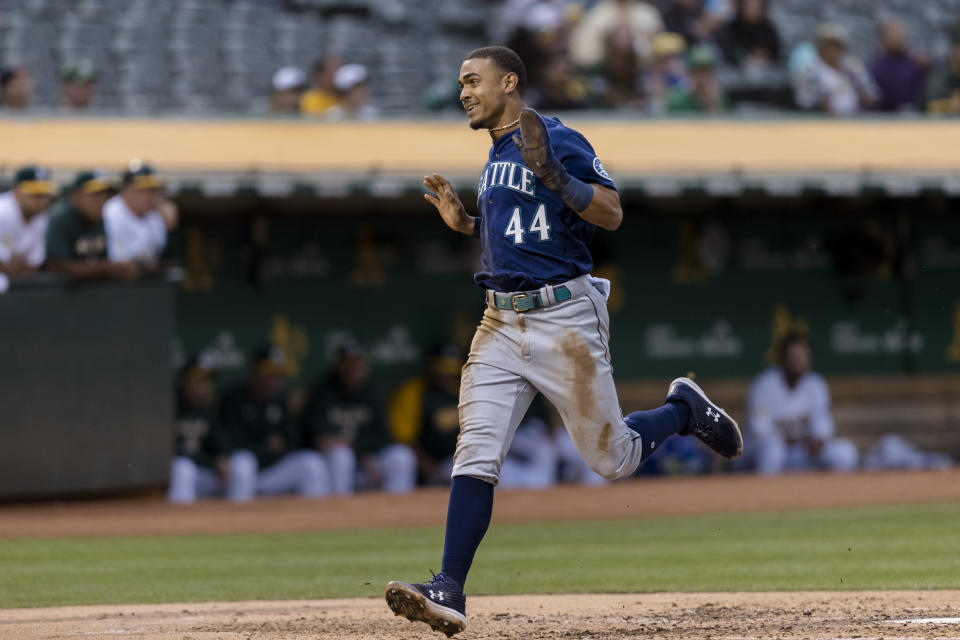 Seattle Mariners' Julio Rodriguez reacts as he runs home to score against the Oakland Athletics on a single by Jesse Winker during the third inning of a baseball game in Oakland, Calif., Wednesday, June 22, 2022. (AP Photo/John Hefti)