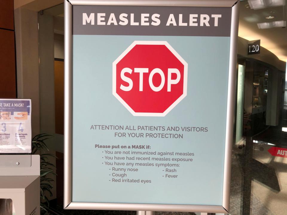 In this Jan. 30, 2019, file photo, a sign posted at The Vancouver Clinic in Vancouver, Wash., warns patients and visitors of a measles outbreak. The focus on measles in the Pacific Northwest intensified Friday, March 1, 2019, as public health officials in Oregon announced a new case of the highly contagious disease unrelated to an ongoing outbreak in Washington state that's sickened 68 people so far.