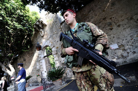 Italian Army soldiers patrol at the entrance of the San Domenico Hotel where leaders from the world's major Western powers will hold their annual summit, in the Sicilian town of Taormina, Italy, May 24, 2017. REUTERS/Guglielmo Mangiapane