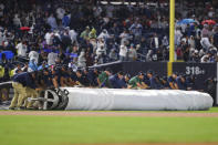 The grounds crew rolls out the tarp during the sixth inning of a baseball game between the New York Yankees and Boston Red Sox, Sunday, Sept. 25, 2022, in New York. (AP Photo/Jessie Alcheh)