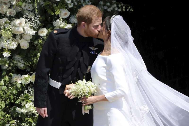 英國哈利王子與梅根於19日舉行婚禮，婚禮儀式結束後，兩人在準備搭馬車前深情一吻（美聯社）