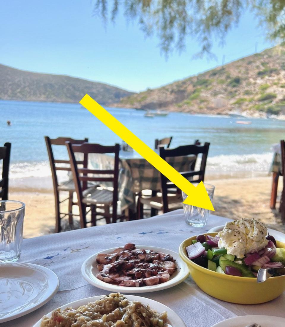 A salad with soft cheese on top and other lunch items on a table.