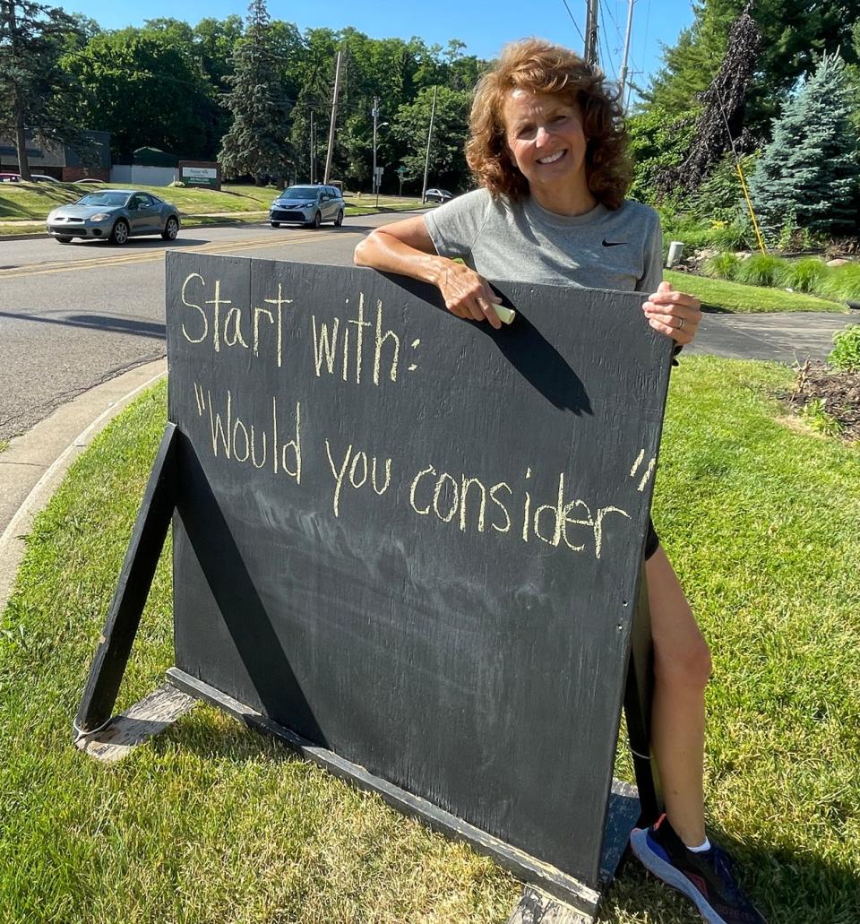 Jonna Siano poses beside her chalkboard sign along Capital Avenue Southwest on Thursday, June 30, 2022. Siano started writing daily messages of positivity on the sign when the pandemic began in 2020.