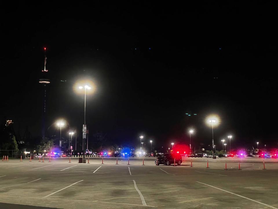 Emergency vehicles are shown in the parking lot of Six Flags Great America in Gurnee, Ill., Sunday night, Aug. 14, 2022. Three people were injured in a shooting in the parking lot that sent visitors scrambling for safety, authorities said.