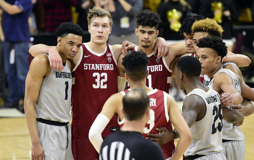 Colorado and Stanford players gather to say a prayer for Stanford's Oscar Da Silva, who had hit his head on the floor in a collision during the second half of an NCAA college basketball game Saturday, Feb. 8, 2020, in Boulder, Colo. (AP Photo/Cliff Grassmick)