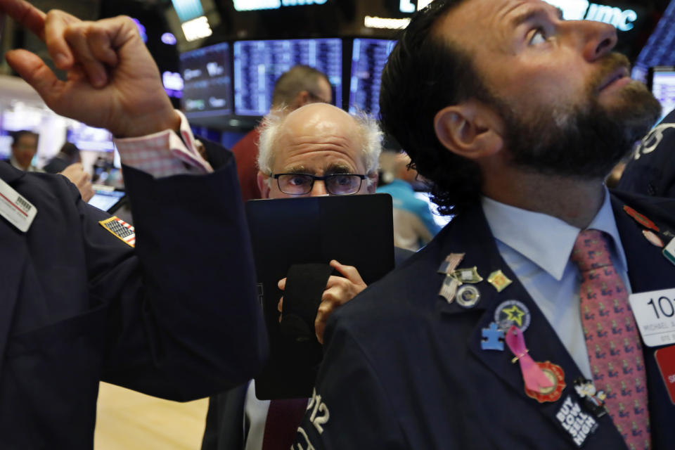 FILE - In this Nov. 4, 2019, file photo trader Peter Tuchman, center, works on the floor of the New York Stock Exchange. Markets are coming off a fabulous 2019, where stocks, bonds and other investments climbed in concert. But for the next year, and decade, in fact, Wall Street is telling investors to set their expectations considerably lower. (AP Photo/Richard Drew, File)