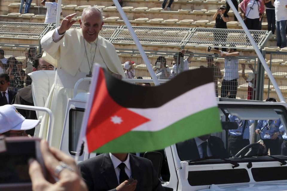 Pope Francis waves to the faithful upon his arrival to attend a mass in Amman