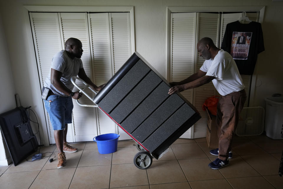 Cousin Johnny McGriff, left, and uncle Billy McGriff Sr. help move furniture for Freddie Davis, as Davis prepares for an eviction that could come at any time, Monday, Sept. 6, 2021, in the ground floor one-bedroom apartment where he has lived for almost four years, in Miami. Davis' landlord raised his rent by 60 percent in August 2020, the same month he lost his job as a truck driver when the company he worked for folded during the pandemic. (AP Photo/Rebecca Blackwell)