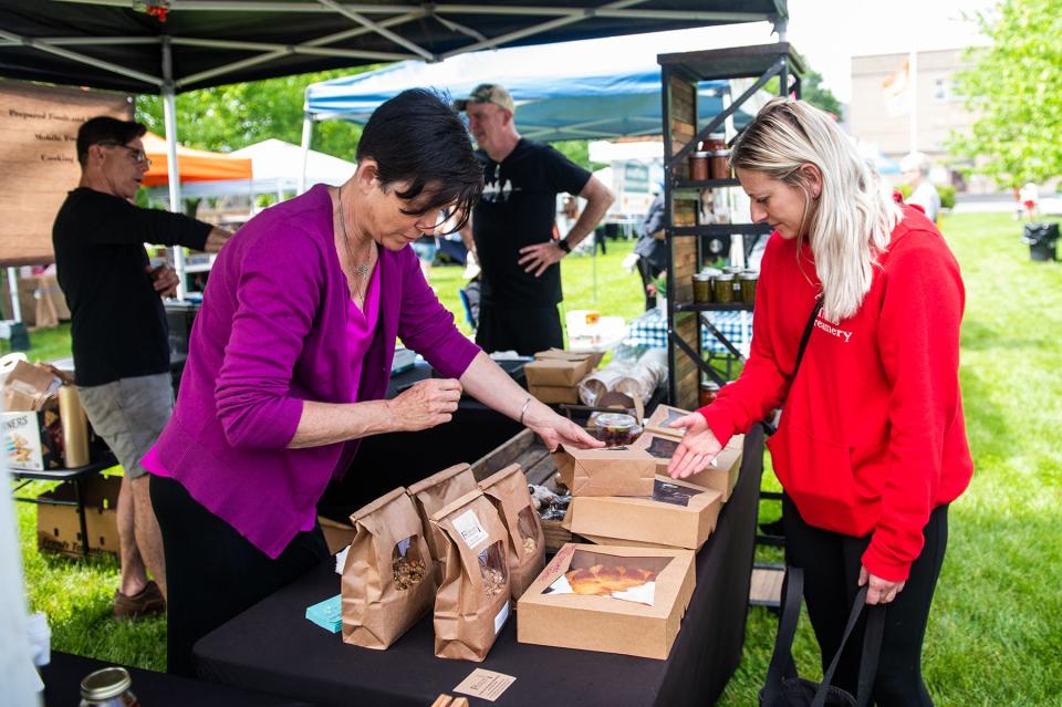Jodie Rocchio, owner of the The Fearless Cooking Company, left, helps customer Denise Guion, from Trailside Treats Creamery, right, at the Goshen Farmers Market in Goshen, NY on Friday, May 20, 2022. KELLY MARSH/FOR THE TIMES HERALD-RECORD