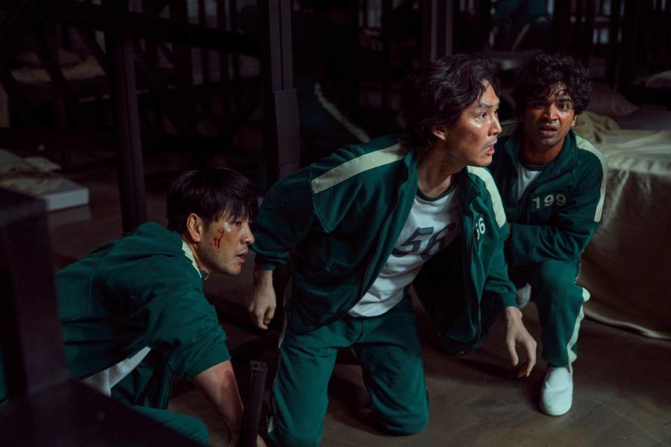 This undated photo released by Netflix shows South Korean cast members, from left, Park Hae-soo, Lee Jung-jae and Anupam Tripathi in a scene from “Squid Game.” Squid Game, a globally popular South Korea-produced Netflix show that depicts hundreds of financially distressed characters competing in deadly children’s games for a chance to escape severe debt, has struck a raw nerve at home, where there’s growing discontent over soaring household debt, decaying job markets and worsening income inequality. (Youngkyu Park/Netflix via AP)