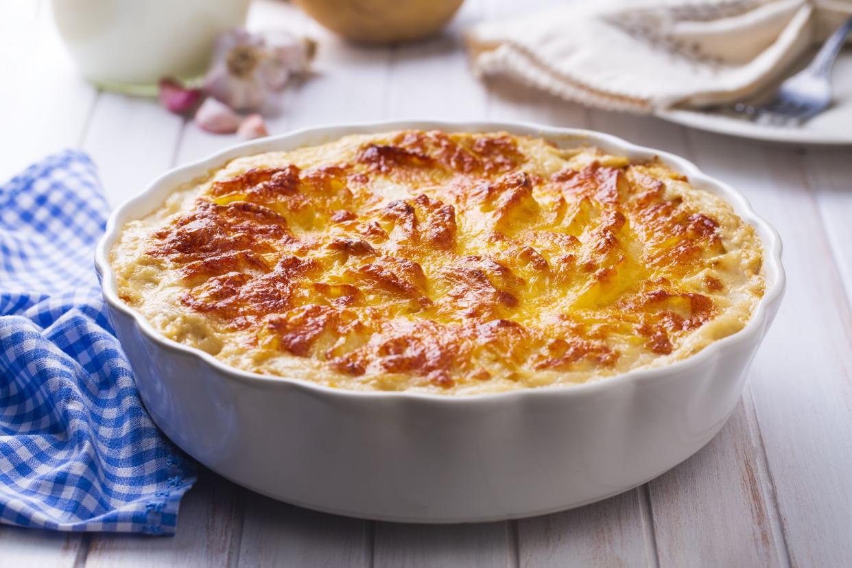 Potato gratin - graten (baked potatoes with cream and cheese) with rosemary and forks (Turkish name; Kremali patates)