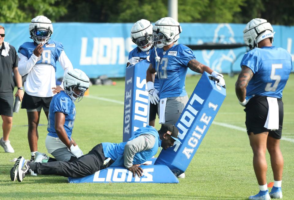 (From left) Lions running backs Justin Jackson, Jermar Jefferson, Jahmyr Gibbs, Craig Reynolds and David Montgomery listen as running backs coach Scotty Montgomery explains a drill during training camp on Wednesday, July 26, 2023, in Allen Park.