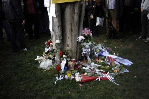 Flowers are placed at the place where an eldery man shot himself in Syntagma square in Athens. An elderly man shot himself in the head Wednesday, drawing an emotional response from Greeks who flooded the area in a spontaneous anti-government protest