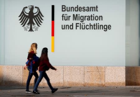 FILE PHOTO: People walk in front of an office building of the Federal Office for Migration and Refugees (BAMF) in Berlin, Germany, October 15, 2017. REUTERS/Fabrizio Bensch/File Photo