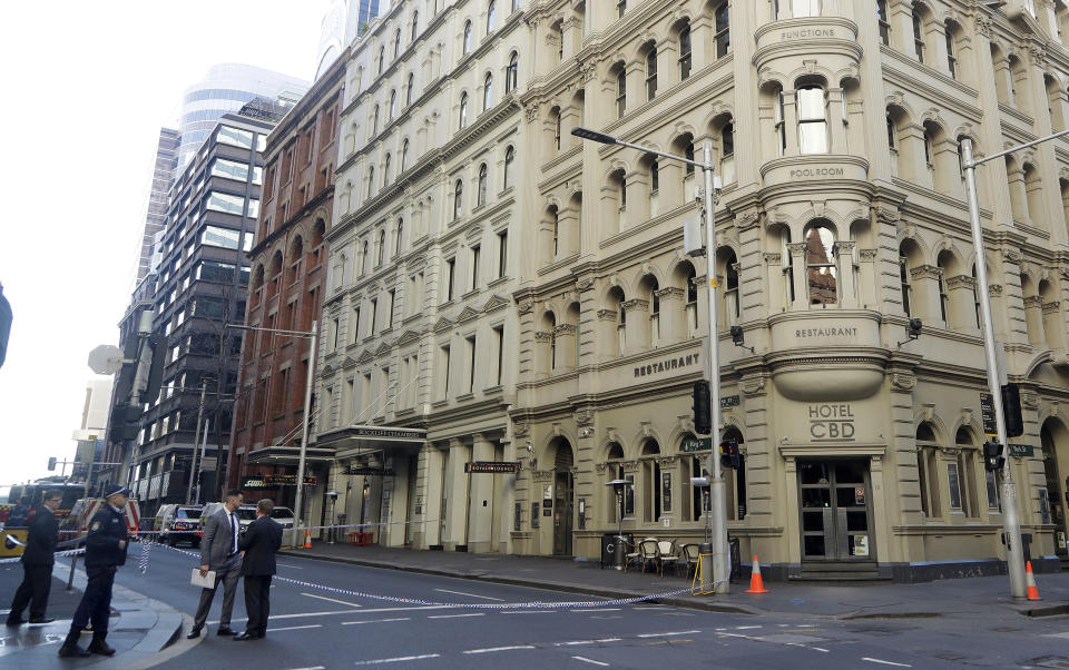 Police, at bottom left, work at a scene where a man attempted to stab multiple people in Sydney, Australia, Tuesday, Aug. 13, 2019. Police and witnesses say a knife-wielding man yelling "Allahu akbar," or "God is great," has attempted to stab several people before being arrested, with one person taken to a hospital. (AP Photo/Rick Rycroft)