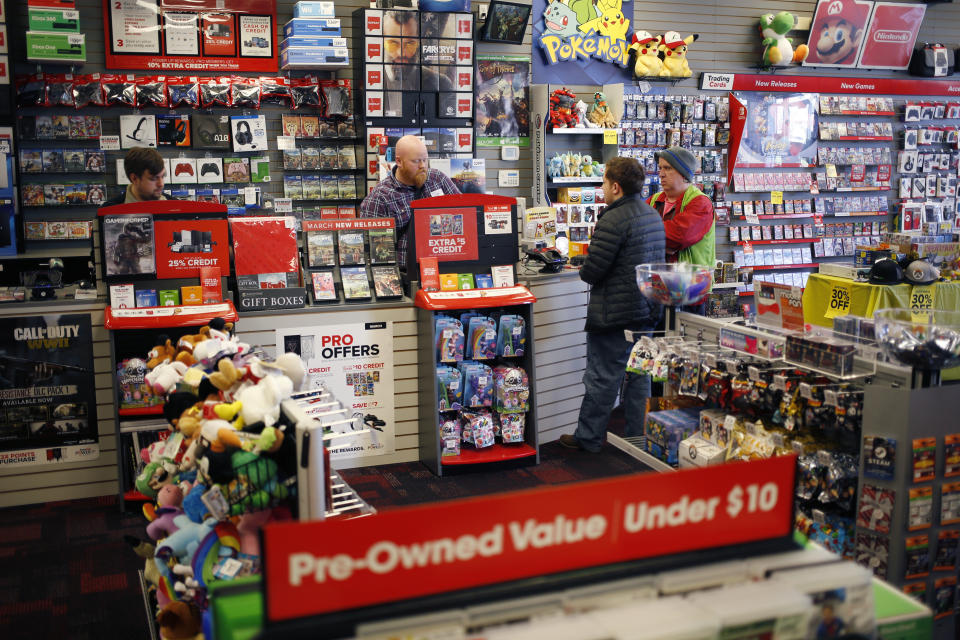 An employee assists customers inside a GameStop Corp. store in Louisville, Kentucky, U.S., on Thursday, March 15, 2018. GameStop Corp. is scheduled to release earnings figures on March 28. Photographer: Luke Sharrett/Bloomberg via Getty Images