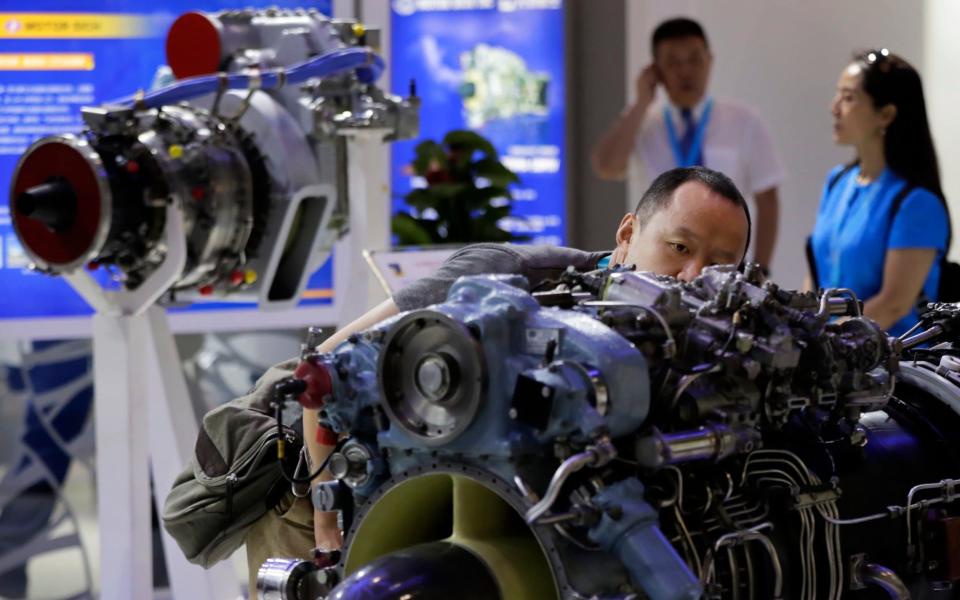 A man takes a closer look at a helicopter engine on display at an aviation exhibition in Beijing last week - AP
