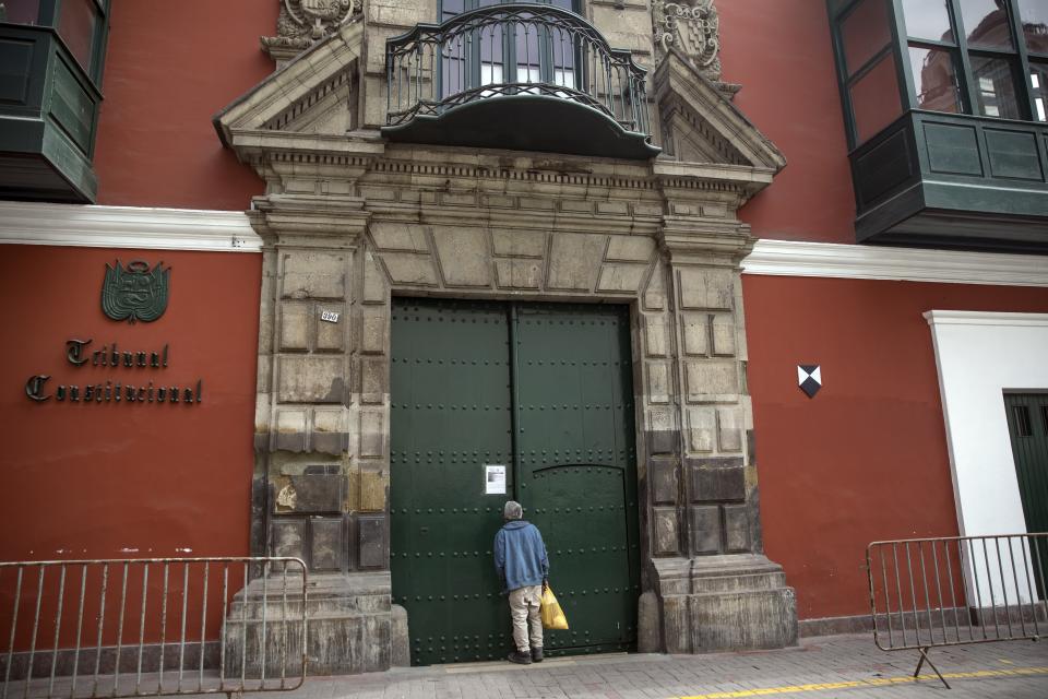 Elías Chávez, de 71 años, observa a través de la puerta principal del edificio del Tribunal Constitucional en Lima, Perú, el jueves 17 de septiembre de 2020. (AP Foto/Rodrigo Abd)