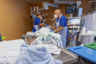 Medical staff members treat a coronavirus patient in the ICU of the Asklepios Clinic in Munich, Germany, Thursday, Nov. 4, 2021 as the country has been experiencing an increasing number of COVID-19 cases. (Peter Kneffel/dpa via AP)