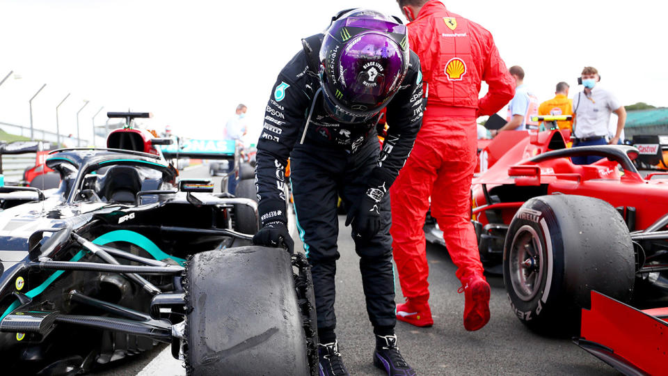 Lewis Hamilton, pictured here inspecting his punctured tyre.