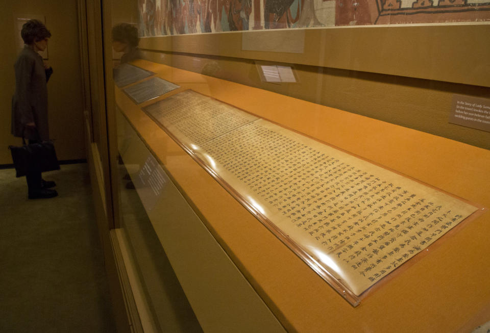 A handwritten Buddhist scripture, from the Tang Dynasty, 618-907 AD, is displayed in "Dunhuang: Buddhist Art at the Gateway of the Silk Road," at the China Institute, in New York, Tuesday, April 24, 2013. (AP Photo/Richard Drew)