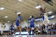 In this Thursday, Feb. 27, 2020 photo, Merrimack College forward Idris Joyner, right, drives to the basket ahead of Central Connecticut defenders during the first half of an NCAA college basketball game in North Andover, Mass. The Warriors have been one of the biggest surprises in college basketball, winning more games than any other first-year Division I program in history. (AP Photo/Mary Schwalm)