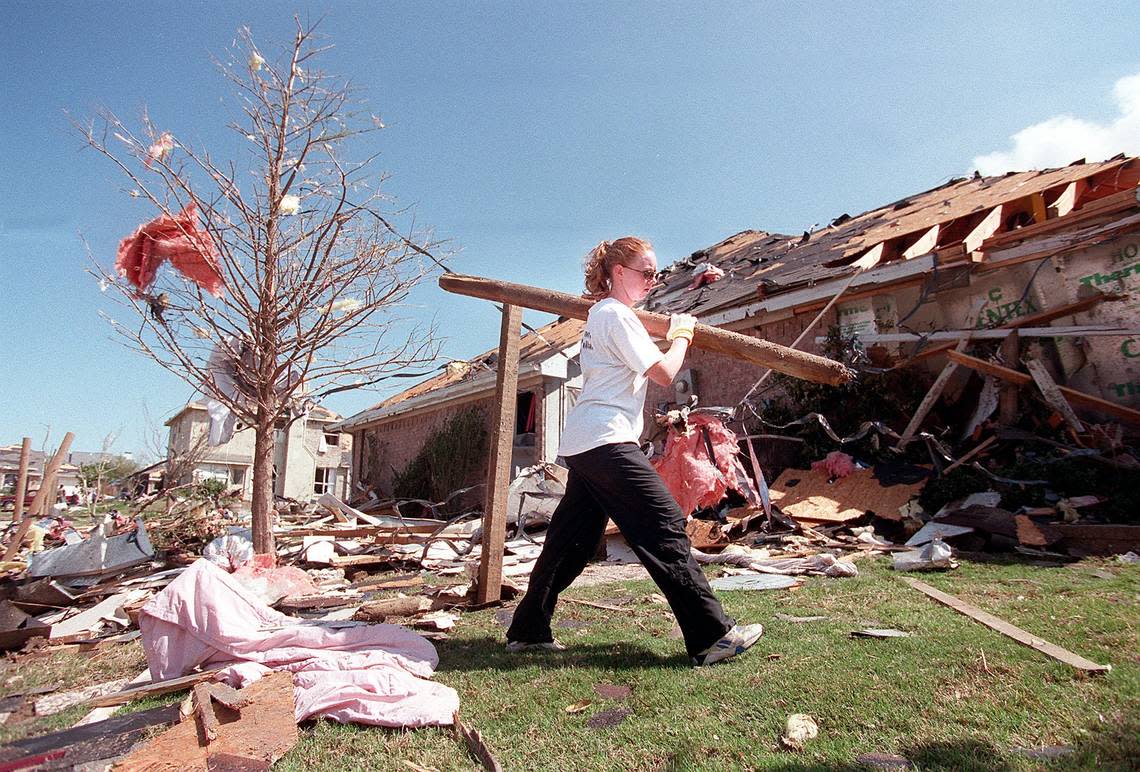 Jill Love of North Dallas helps carry debris from her parents’ home at 201 Manor Way in South Arlington after a tornado on March 28, 2000.