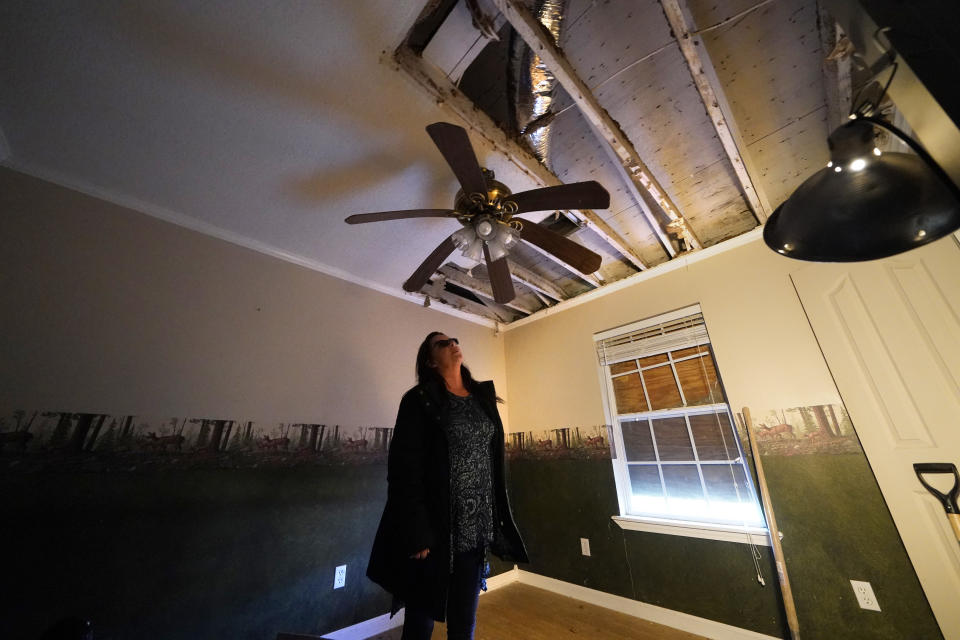 A warped ceiling fan hangs near a hole in the roof of Dewana Young's heavily damaged home, in the aftermath of both Hurricane Laura and Hurricane Delta, in Grand Lake, La., Friday, Dec. 4, 2020. (AP Photo/Gerald Herbert)