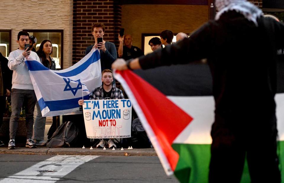 A group holding an Israeli flag sit across the street from the gathering of support for Palestine at the Allen Street gates on Thursday, Oct. 12, 2023. Abby Drey/adrey@centredaily.com