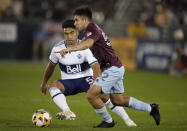 Colorado Rapids midfielder Braian Galvan, front, pursues the bal with Vancouver Whitecaps midfielder Michael Baldisimo in the second half of an MLS soccer match Sunday, Sept. 19, 2021, in Commerce City, Colo. The game ended in a 1-1 tie. (AP Photo/David Zalubowski)