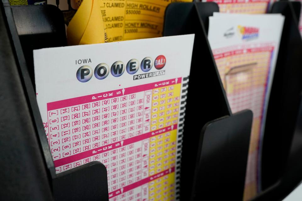 In this Jan. 12, 2021 file photo, blank forms for the Powerball lottery sit in a bin at a local grocery store, in Des Moines, Iowa. The giant Powerball jackpot has grown even bigger, with officials raising the estimated payout ahead of Saturday, Oct. 2, drawing.